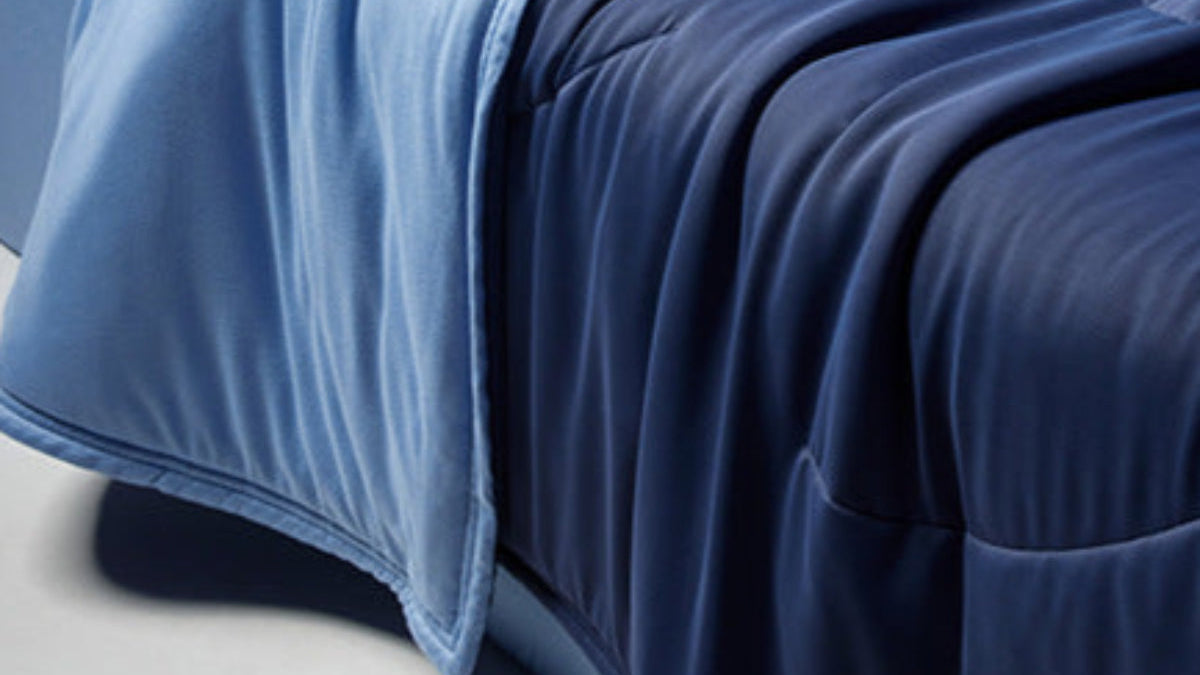 Person lying on a blue inflatable bed with 'Planet' branding against a dark blue background